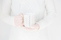 woman in gloves holding a mug 
