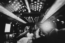 bride and groom kissing in the back of a limo