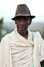 man wearing a hat and a blanket