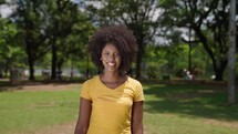 Close up portrait of black woman smiling at the city park on a sunny day
