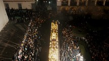 Hundreds Of Cucuruchos People In Robed Carrying Anda Floats In Front Of Antigua Guatemala Cathedral At Night During Processions. - aerial