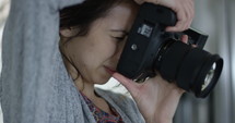 Female photographer take a photo and reviews it
