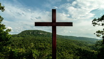 Timelapse of cloud movement over a cross on a hill.