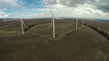 wind turbines at the top of a hill 