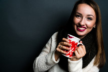 a young woman holding a mug of hot chocolate 