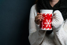 a woman holding a winter mug 