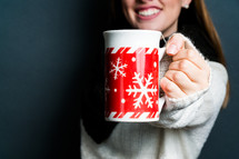 a young woman holding a winter mug 