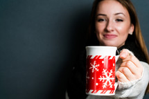 a young woman holding a mug of hot cocoa 