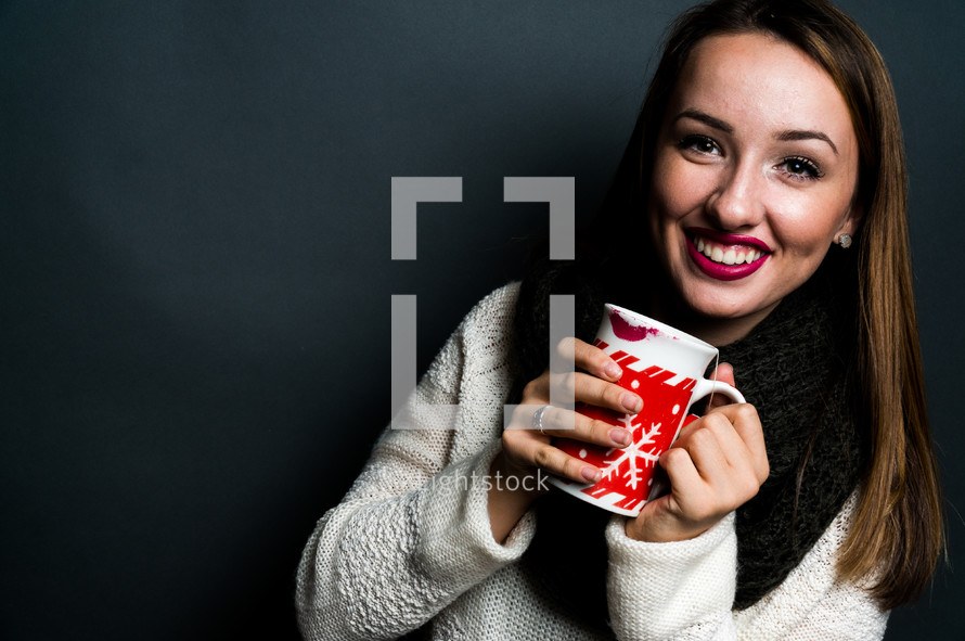 a young woman holding a mug of hot chocolate 