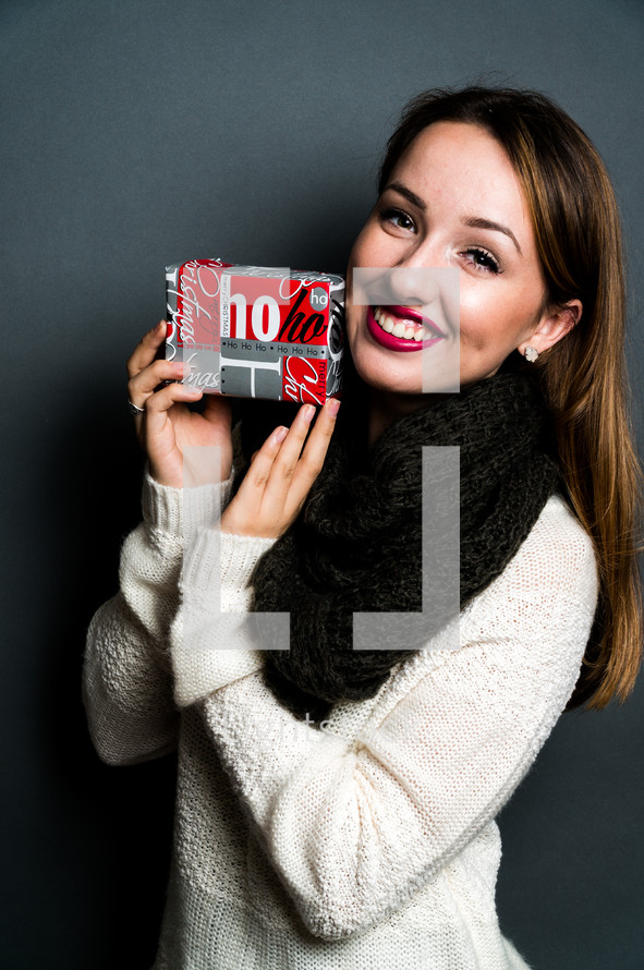 smiling teen girl holding a Christmas gift 