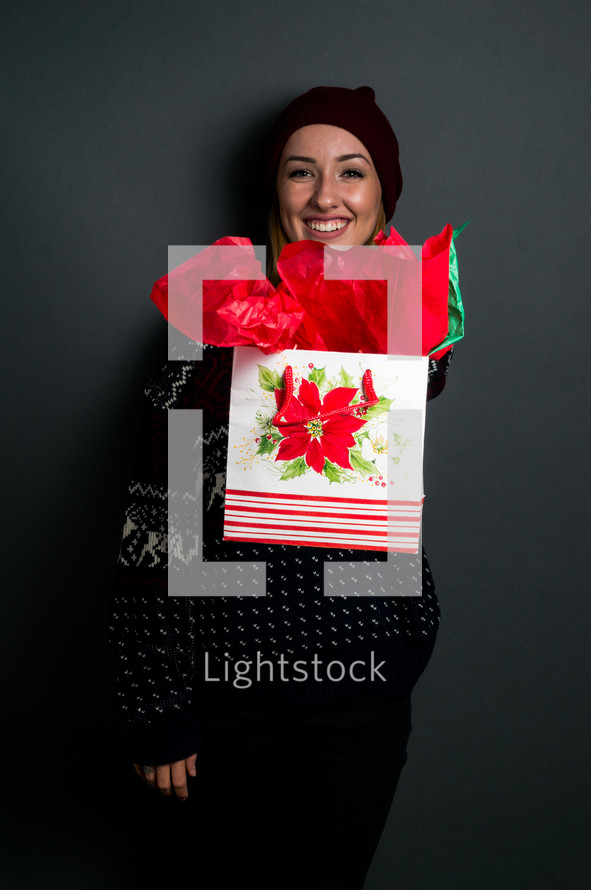 a young woman holding a Christmas gift 