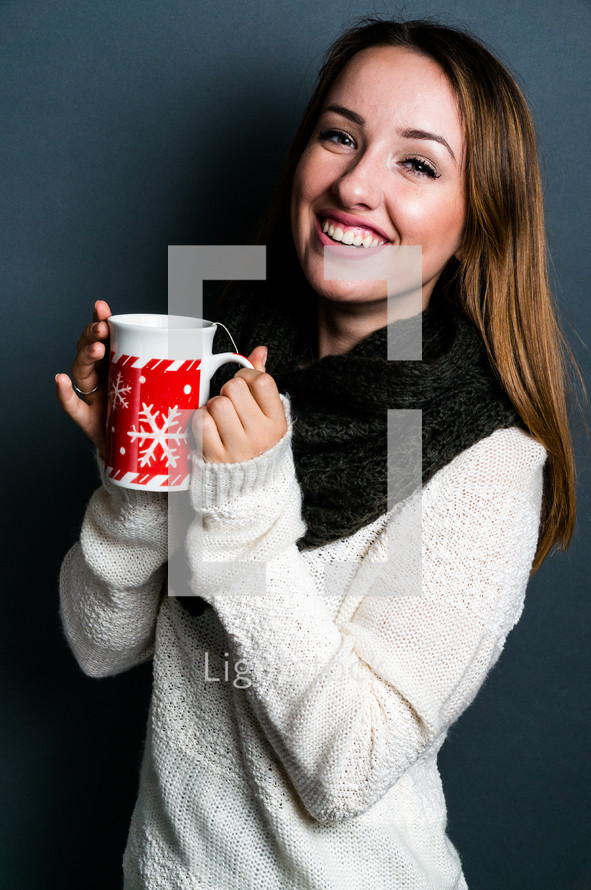 a teen girl holding a mug of hot cocoa 