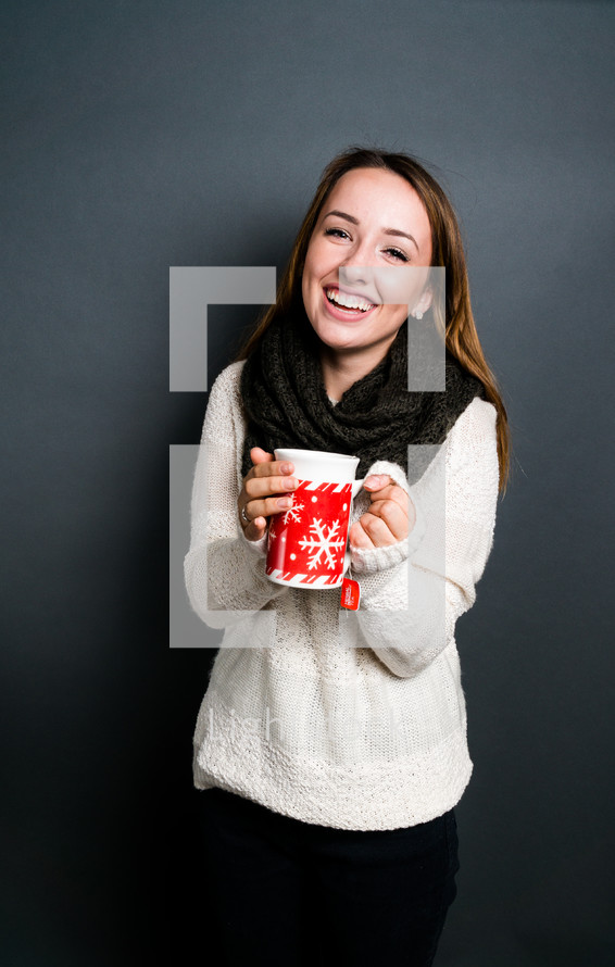 a teen girl holding a winter mug with tea 