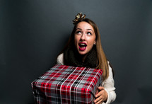 a teen girl holding a wrapped Christmas gift 