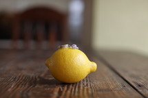 wedding ring and engagement ring on a lemon
