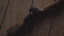 Pirate hand gun laying on floor on pirate ship - panning shot