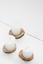 candles on wood slices on a white background 