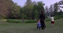 Mother walking with children in field towards mediation circle