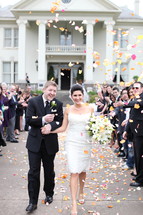 bride and groom leaving for their honeymoon under people throwing leaves