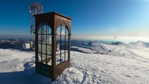 Old And Rusty Telephone Booth Surrounded By White Snow On Top Of The Mountain In Sinaia, Romania On A Sunny Winter Day. - orbiting shot