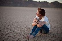 woman sitting on parched ground
