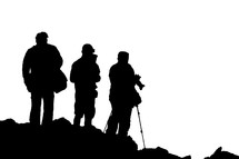 silhouettes of tourists standing in front of a volcano with cameras 