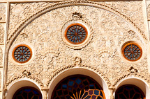 round stain glass windows on a building in Iran 