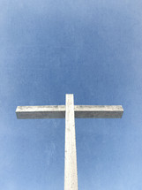 vertical wood cross with light blue sky and distressed texture