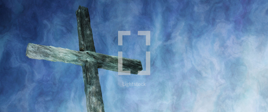rough wood cross against a dramatic blue and white sky 