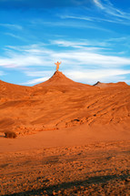 Jesus praying alone on a hill in a desert at golden hour. Biblical concept.
