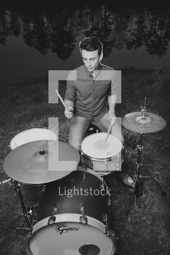 young man playing drums outdoors 