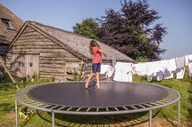 a little girl jumping on a trampoline 