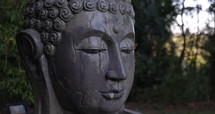 Meditation statue with water flowing from eyes in garden