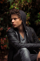 teen boy in a hoodie and leather jacket 