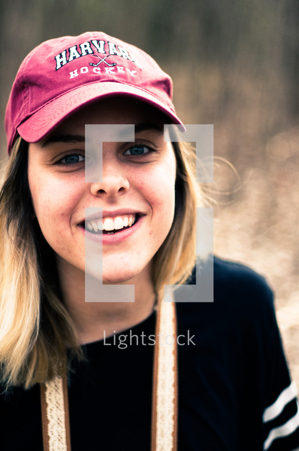 face of a woman in a ball cap 