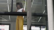 Positive black business woman talking smartphone in office interior. Smiling businesswoman calling mobile phone in Slow motion 
