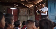 School teacher reading to students in Southeast Asia.