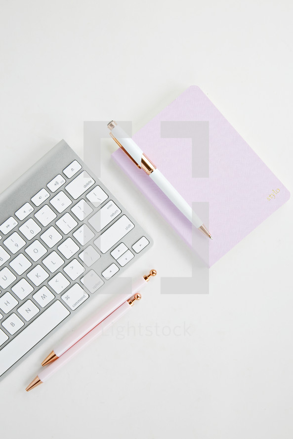 computer keyboard, pen, and notepad 