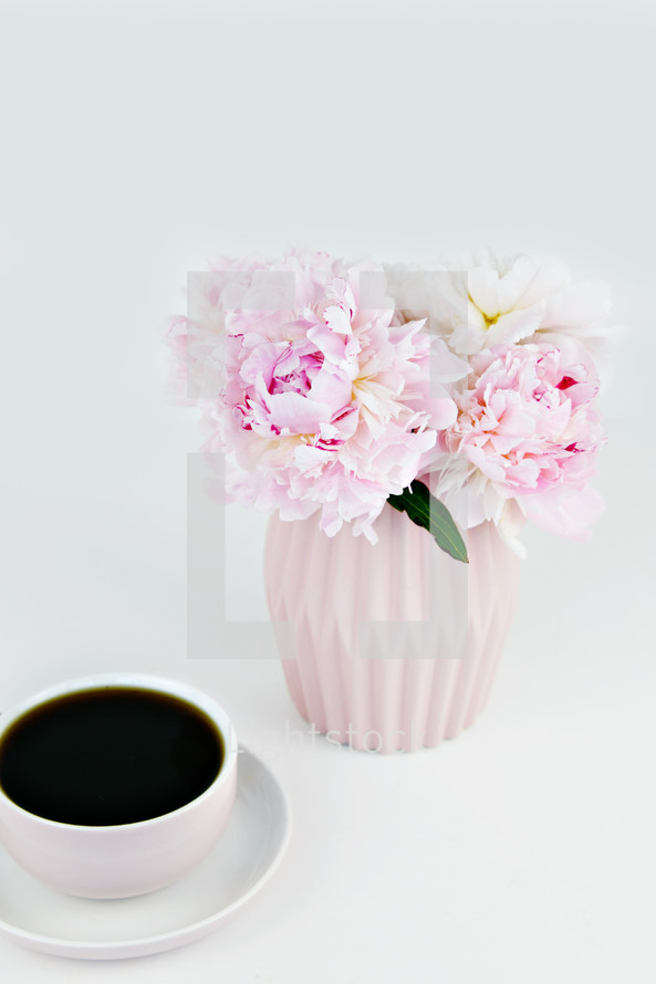 vase of pink flowers and coffee cup 