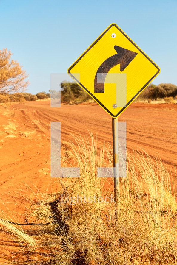 curve road sign and dirt road in Australia 