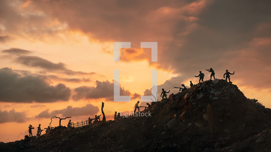 Miniature silhouettes of WWII American and German soldiers fighting under big sunset. War concept
