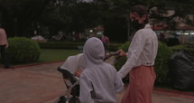 Mother pushing stroller in South America park with son
