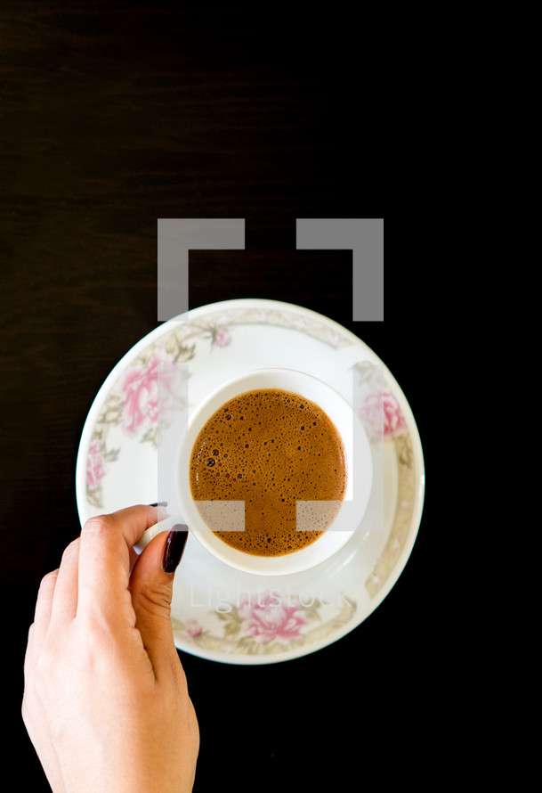 Top View Woman's Hand Holding Coffee Mug on Table