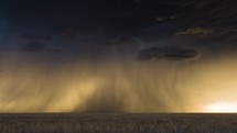 Three Lightning Strikes Flicker Below a Beautiful Storm at Sunset.