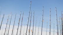 Fishing Rods Lined Up Standing Tall Against A Blue Sky
