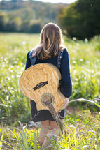 teen girl with a guitar on her back 