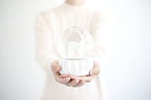 a woman holding a snow globe 