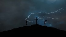 Silhouettes of three crosses on top of a hill in the stormy night. Concept of the Crucifixion of Christ.
