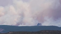 Plane pours flame retardant on smoky fire rising from Hermits Peak Calf Canyon wildfire in New Mexico