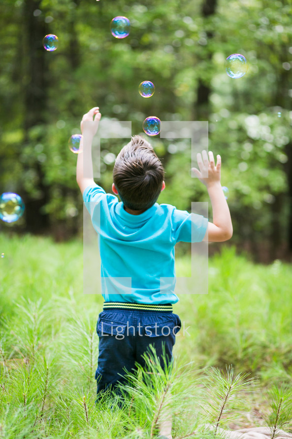 boy chasing bubbles 
